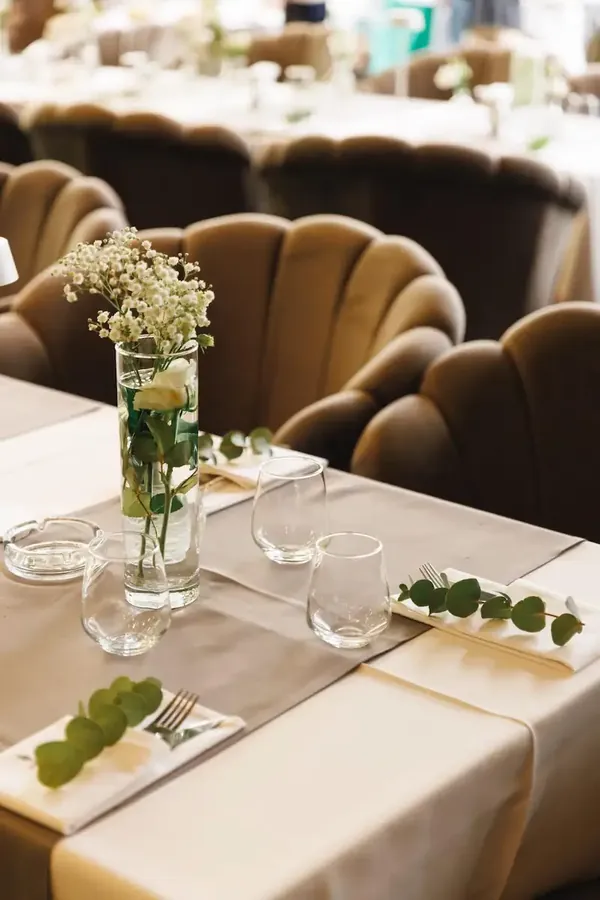 Table set with white flowers and eucalyptus sprigs at an event