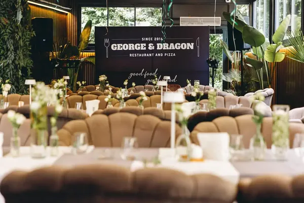 Tables decorated with white flowers in front of the George & Dragon backdrop