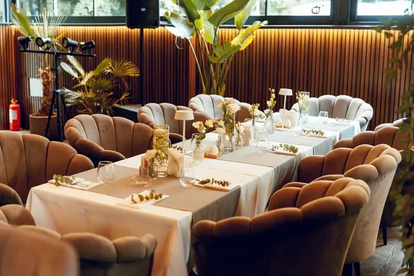 Festive table with white flowers and velvet armchairs for a private event
